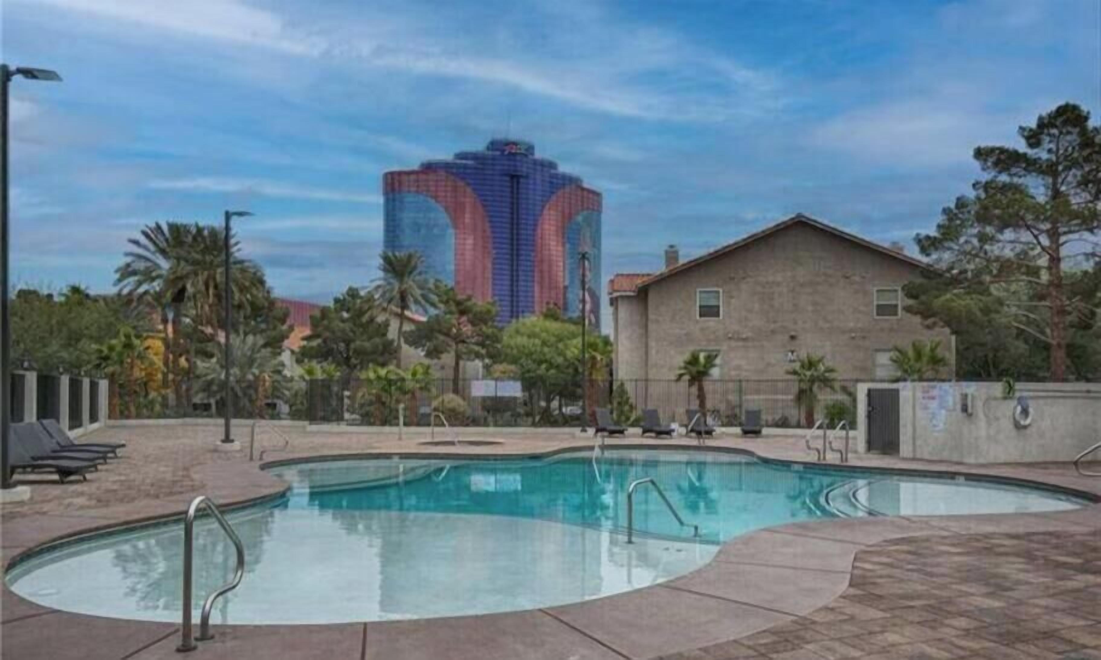 A swimming pool with a view of a tall building in the background.