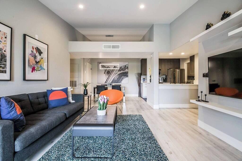 Ein modernes Wohnzimmer mit Sofa, Couchtisch und einem Kunstwerk an der Wand.