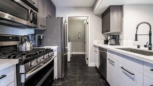 A modern kitchen with a stove, oven, refrigerator, and a coffee maker. - Ruxley Suite Luxury 2b/2b condo (Las Vegas)