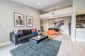 A modern living room with a sofa, coffee table, and artwork on the wall. - Ruxley Suite Luxury 2b/2b condo (Las Vegas)
