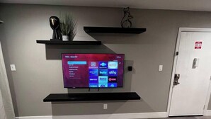 A flat-screen TV mounted on a wall with a digital interface displaying various streaming services. - Dune Suite 2b/1b fully furnished (Las Vegas)