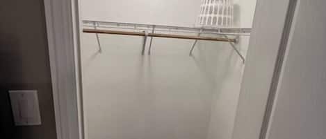 Un pasillo estrecho con piso de madera, una puerta blanca a la derecha y un radiador blanco en la pared.