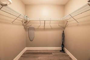A laundry room with a metal drying rack, a vacuum cleaner, and a patterned item hanging on the wall. - Glasgow Suite 1b/1b entire condo (Las Vegas)