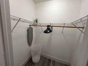 A laundry area with a metal drying rack, a white laundry basket, and a green appliance. - Noma Suite Entire 2bed/2bath (Las Vegas)