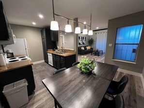 A modern kitchen with a dining area, a built-in oven, and a sink. - Noma Suite Entire 2bed/2bath (Las Vegas)