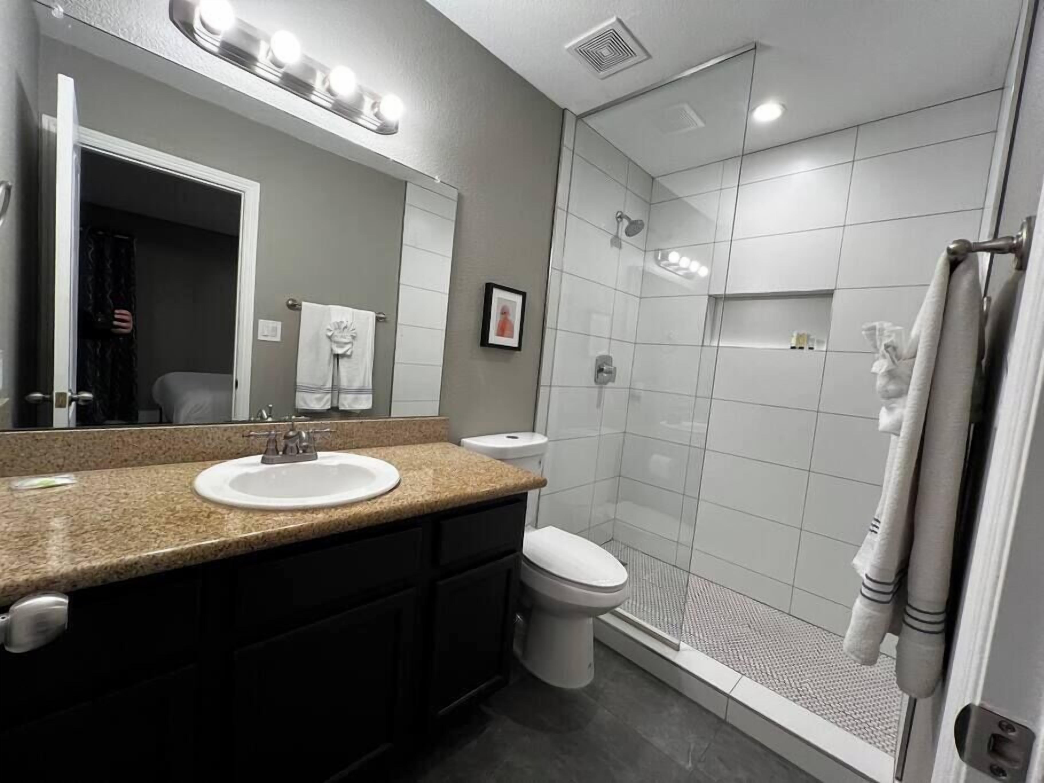 A bathroom with a sink, toilet, and shower.