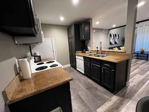 A modern kitchen with a built-in stove, a dishwasher, and a sink. - Noma Suite Entire 2bed/2bath (Las Vegas)