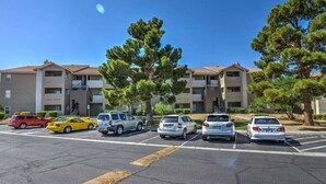 A parking lot with several cars and a row of multi-story buildings with balconies. - Chelsea Suite 2b/2b Strip View! (Las Vegas)