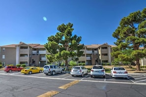 A parking lot with several cars and a row of multi-story buildings with balconies. - Chelsea Suite 2b/2b Strip View! (Las Vegas)
