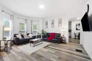 Ein modernes Wohnzimmer mit zwei Sofas, einem Couchtisch und einem Fernseher.