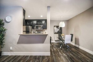 A modern kitchen with dark cabinets, stainless steel appliances, and a central island. - Sundance Suite 2B/2B Central (Las Vegas)