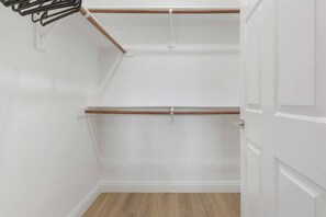 Ein Zimmer mit Holzboden, weißen Wänden und einer Tür.