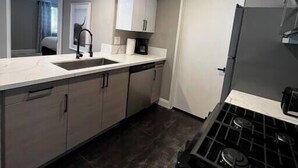 A modern kitchen with a stove, sink, and cabinets. - Huntley Suite Luxury 2b/2b condo (Las Vegas)