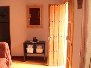 A room with a wooden wardrobe, a small table with baskets, and a mirror on the wall. - La Atalaya de Los Romanes: Tourismus und Urlaub. by Interhome (Los Romanes)