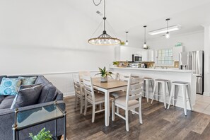 A modern kitchen with white cabinetry, a central island, and bar stools. - Magnolia Pointe 4893-304 |  Pools, Golf, BBQ steps away in Elevator bldg! (Myrtle Beach)