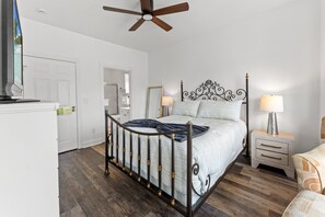 A bedroom with a bed, nightstands, a ceiling fan, and a door leading to a bathroom. - Magnolia Pointe 4893-304 |  Pools, Golf, BBQ steps away in Elevator bldg! (Myrtle Beach)