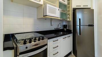 A modern kitchen with a stainless steel stove, a built-in microwave, and a refrigerator.
