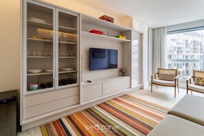 Un salon moderne avec un grand meuble, un téléviseur à écran plat et un tapis à rayures.