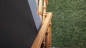 A wooden staircase with a dark wall and a green hedge in the background. - View of the Mountains! Private home with a terrace, ideal for families (Ollantaytambo)