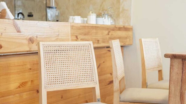 A wooden chair with a woven backrest and cushioned seat, placed on a herringbone-patterned floor. - View of the Mountains! Private home with a terrace, ideal for families (Ollantaytambo)