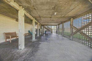 Un espacio interior con piso de concreto, bancos de madera y una escalera que lleva a un nivel superior.
