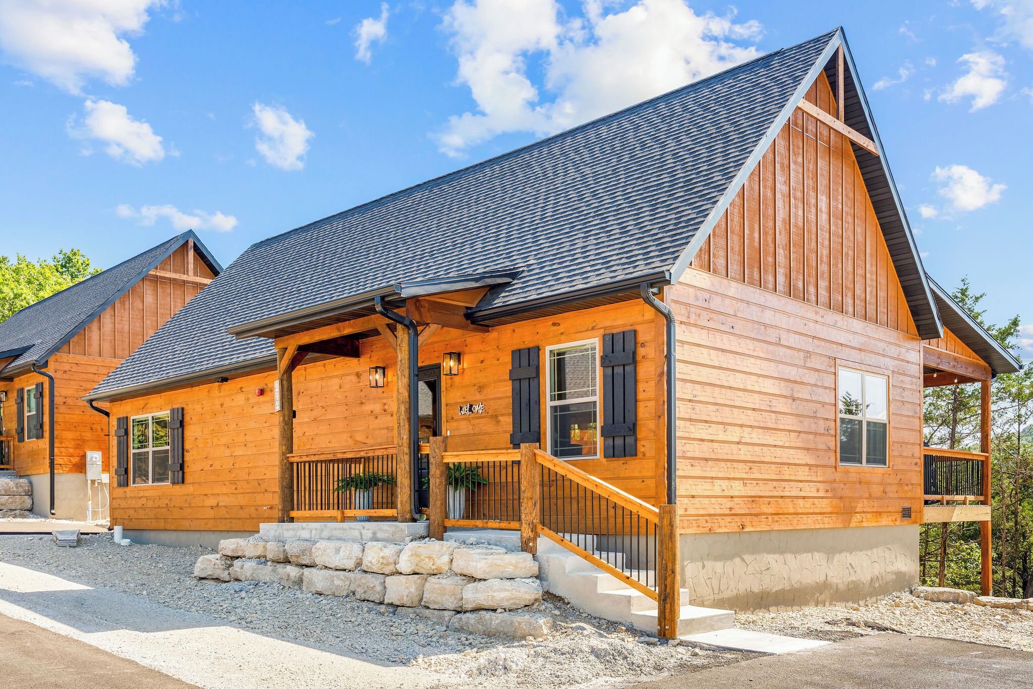 A wooden cabin with a sloped roof, stone steps, and a wooden porch.