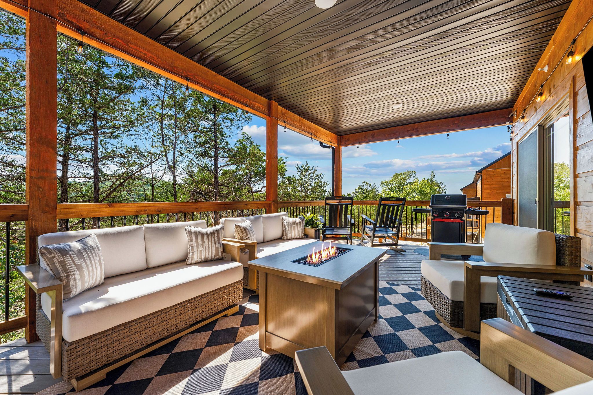 Een terras buiten met een bank, een tafel en een barbecue.