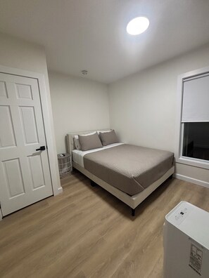 A bedroom with a bed, a door, and a window. - Stylish and cozy retreat, Utica (Utica)