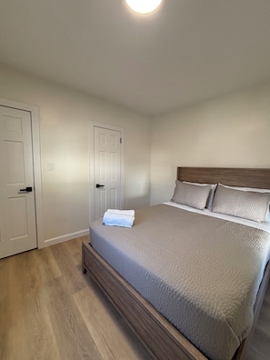 A bedroom with a bed, two doors, and a light fixture. - Stylish and cozy retreat, Utica (Utica)