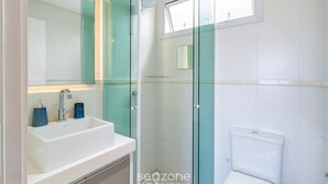 A modern bathroom with a glass shower enclosure, a white sink, and a toilet. - Complete Studio 900 m From Lagoa Ecm0206 (Florianópolis)