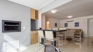 Una cocina moderna con horno empotrado, un comedor con mesa y sillas, y una sala de estar con sofá.