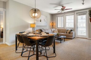 A dining area with a table set for four, a sofa, a coffee table, and a ceiling fan. - Ski In Out Condo 4549 I Huge Hot Tub I Views I Heated Garage I Discounted Attractions (Winter Park)