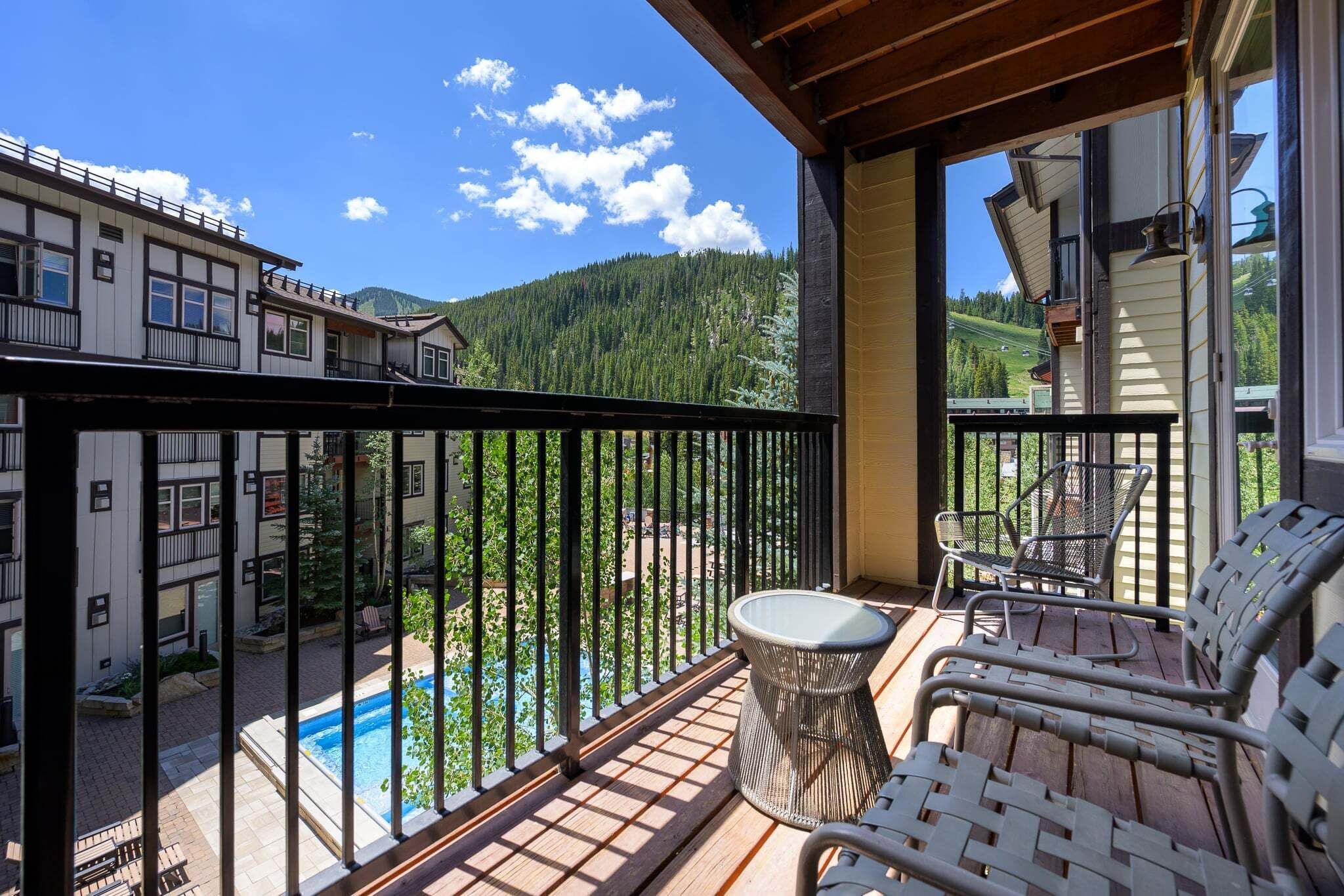 Ein Balkon mit Blick auf einen Berg, ein Schwimmbad und einen Stuhl.