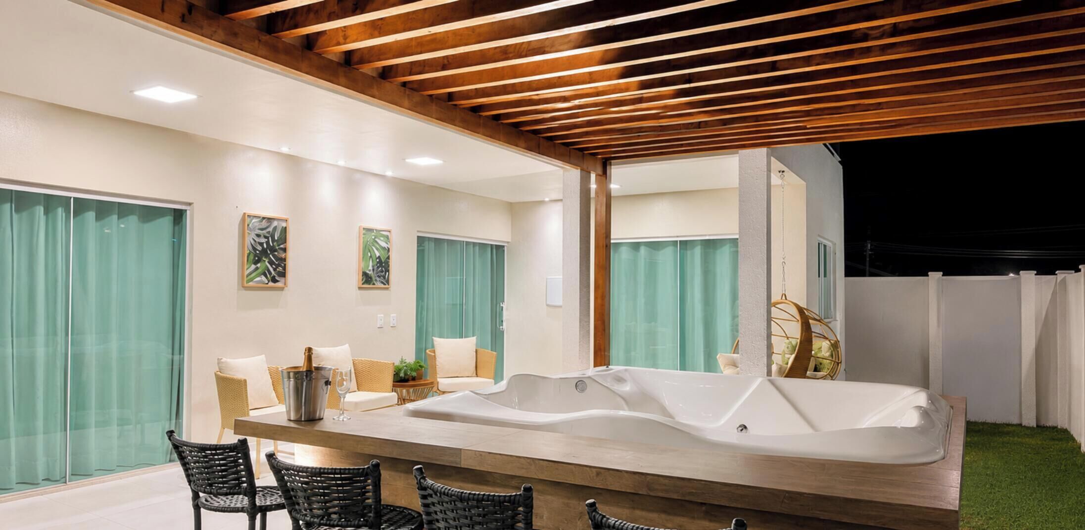 A modern bathroom with a freestanding bathtub, a wooden ceiling, and a large mirror.