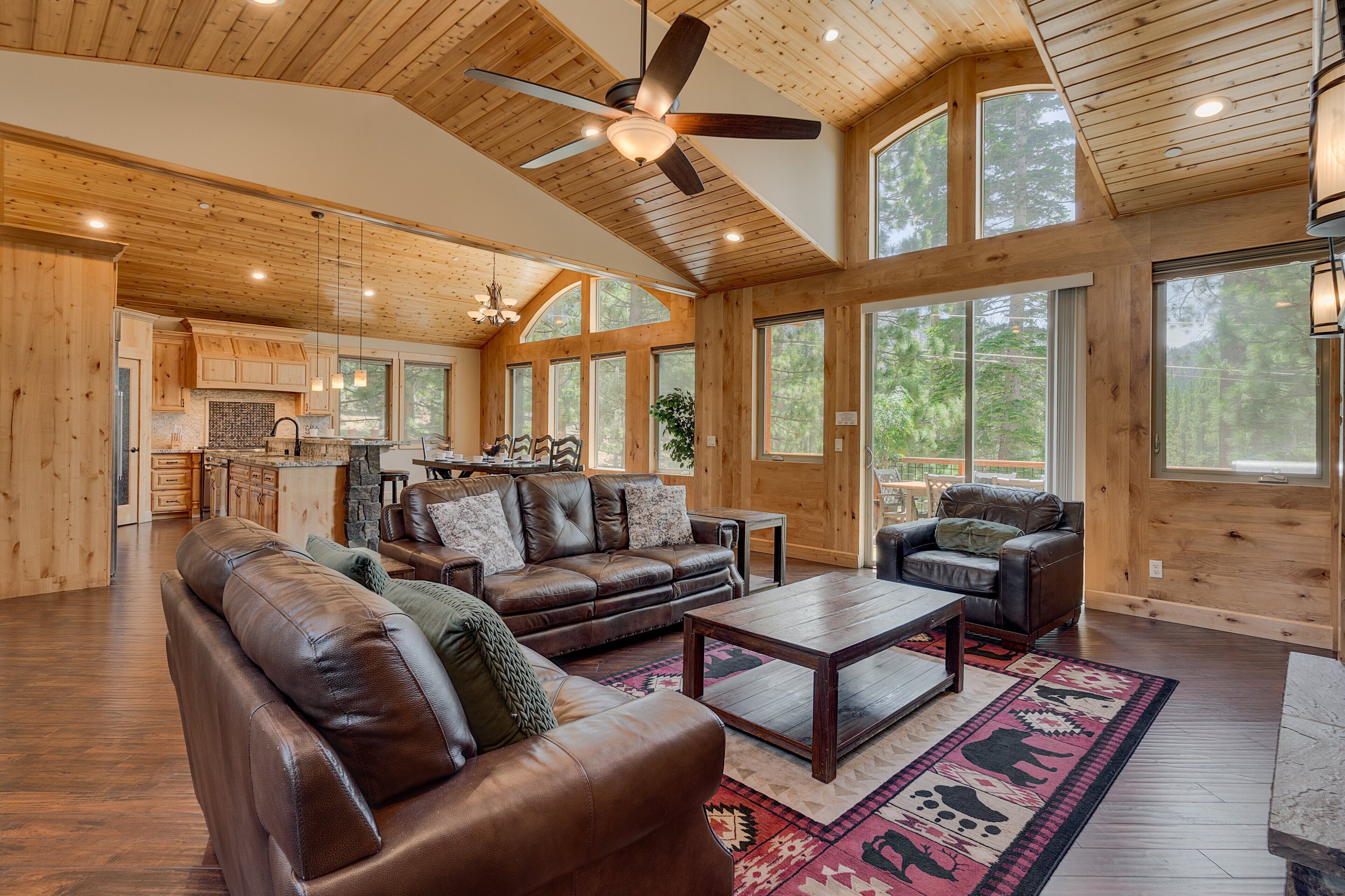 A spacious living area with a fireplace, leather sofas, and a dining table.