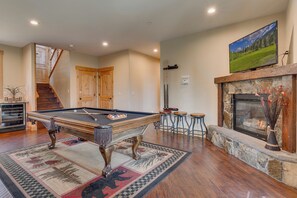A pool table in a room with a fireplace, wooden flooring, and a painting on the wall. - Game Room, Pool Table, Foosball, Arcade, Fireplace, Chef's Kitchen, Hot Tub, Sauna: Big Bear Lodge (South Lake Tahoe)