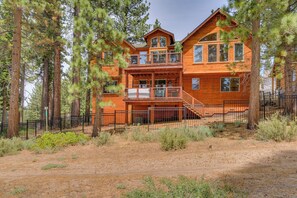 A two-story log cabin with a balcony, surrounded by pine trees. - Game Room, Pool Table, Foosball, Arcade, Fireplace, Chef's Kitchen, Hot Tub, Sauna: Big Bear Lodge (South Lake Tahoe)