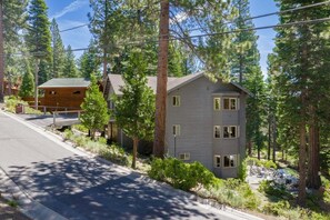 A two-story cabin with a sloped roof, surrounded by dense forest. - Karaoke, Pool Table, Arcade, Outdoor Games, Bubble Dome, Grill, Spa: Starfall Lodge (Tahoe Vista)