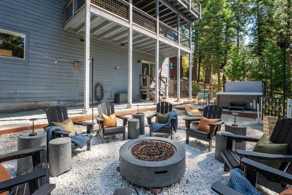 An outdoor seating area with Adirondack chairs, a fire pit, and a grill. - Karaoke, Pool Table, Arcade, Outdoor Games, Bubble Dome, Grill, Spa: Starfall Lodge (Tahoe Vista)