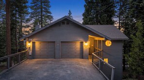 A two-car garage attached to a house with a metal railing and a small porch.