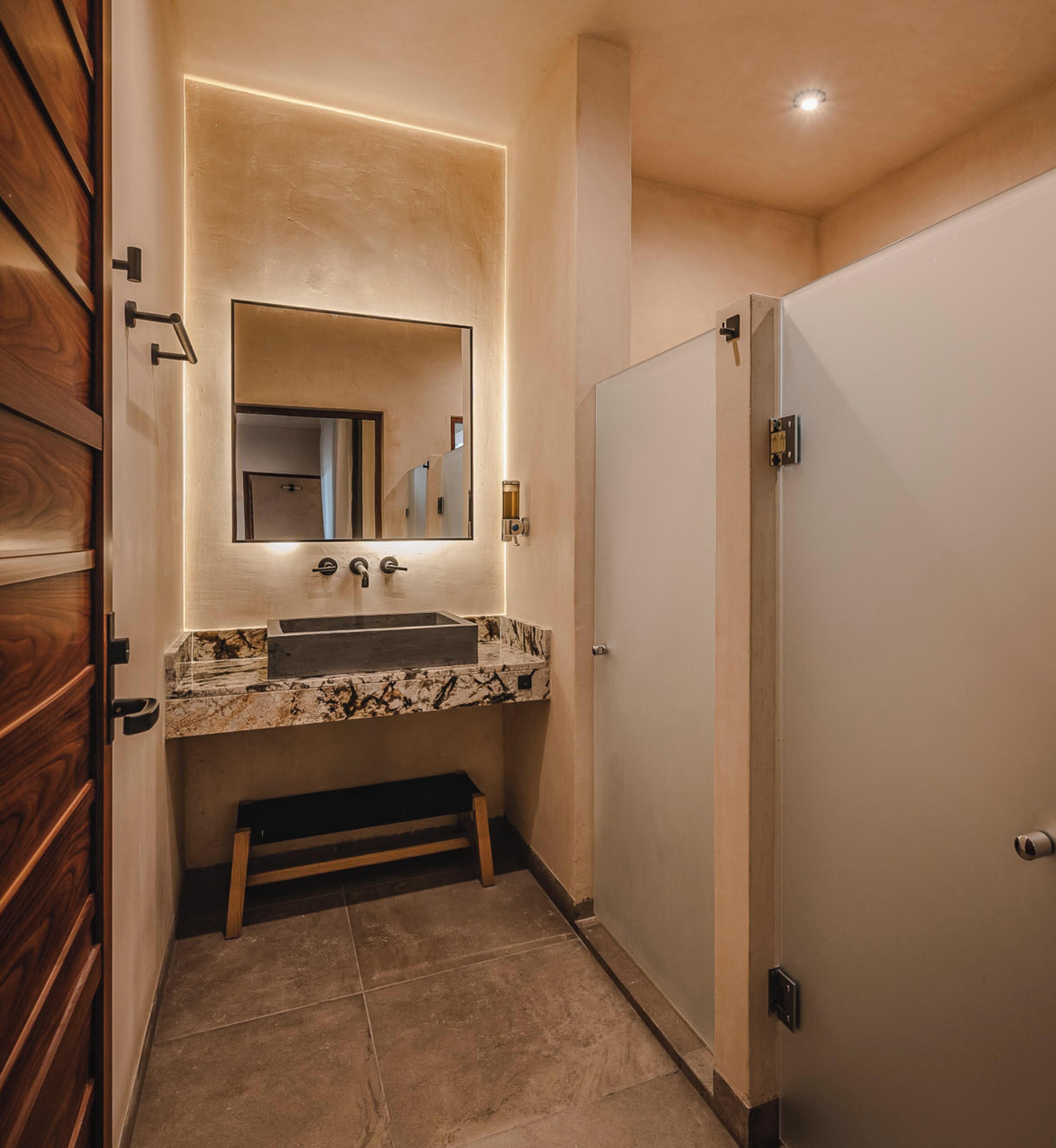 Une salle de bain avec un lavabo en marbre, un miroir et une cabine de douche.