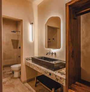 Un baño con un lavamanos grande, un espejo y una ducha.