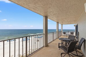 Ein Balkon mit Blick auf Strand und Meer.