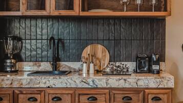 A kitchen with wooden cabinets, a marble countertop, and various kitchen appliances.