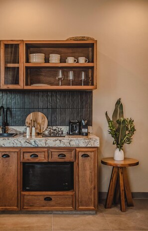 Una cocina con armarios de madera, encimera de mármol y una pequeña planta en maceta.