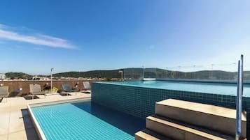 A rooftop swimming pool with a clear view of the surrounding landscape.