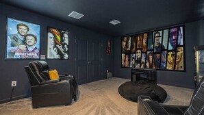Ein Heimkino mit Liegesessel, Sitzsack und Filmplakaten an der Wand.