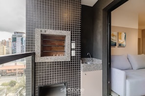 A modern bathroom with a built-in sink, a shower area, and a view of the city. - Apartment With Pool in Downtown Floripa Lgd0201 (Florianópolis)