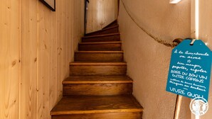 Una escala de fusta amb un senyal a la paret.