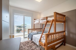 Une chambre avec un lit superposé offrant une vue sur la ville, une petite table et un tapis moelleux.